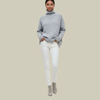 Grey oversized roll-neck knit jumper with ribbed cuffs, styled with white trousers