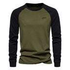 Green raglan long sleeve cotton t-shirt worn with dark trousers