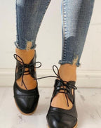 Black vintage lace-up block-heel brogue T-strap shoes, worn with jeans