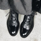 Product photo of the black lace-up leather cap-toe ankle boots for autumn