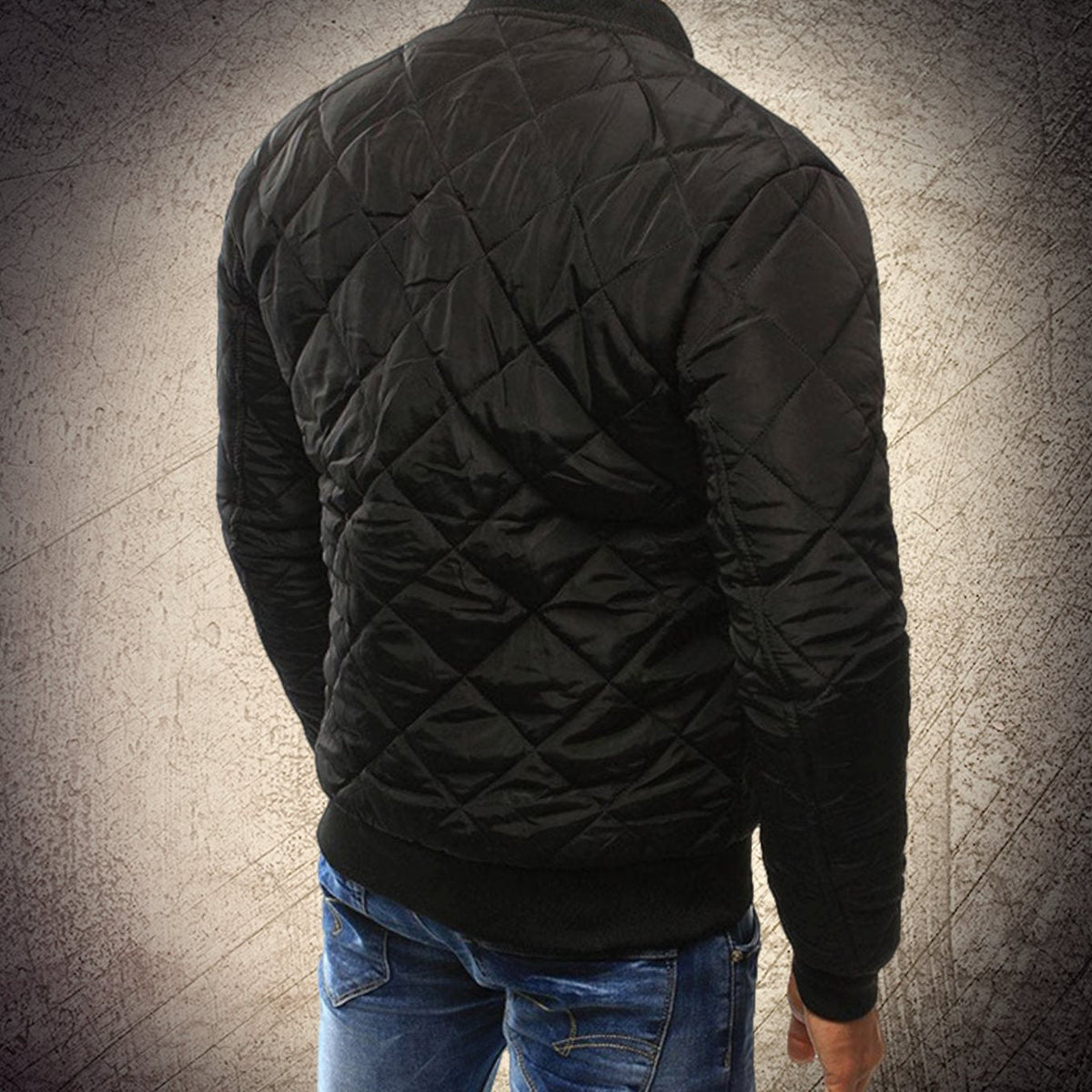 Black quilted bomber jacket, back view highlighting the ribbed hem