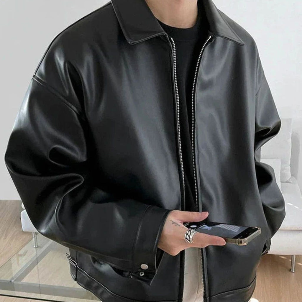 Men's oversized faux leather bomber jacket in black with buttoned cuffs.