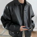 Men's oversized faux leather bomber jacket in black with buttoned cuffs.