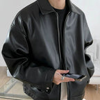 Men's oversized faux leather bomber jacket in black with buttoned cuffs.