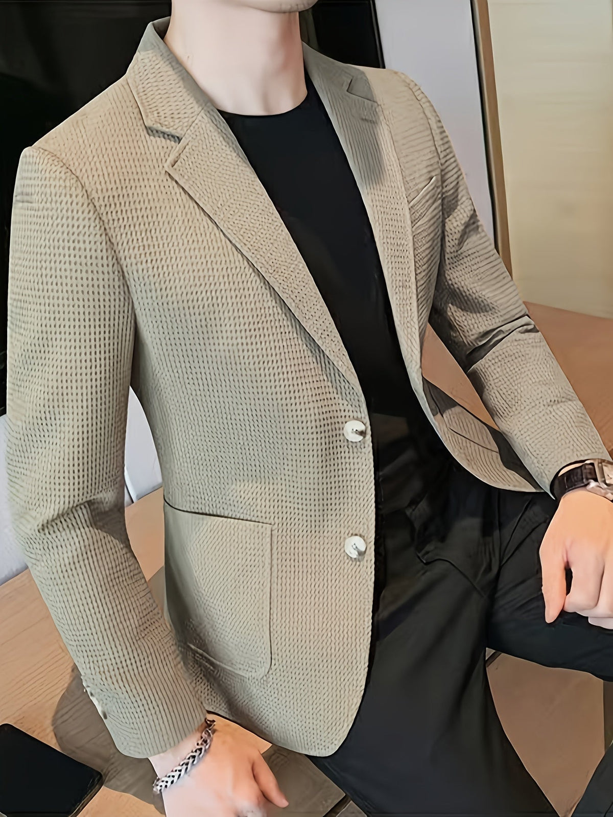 Beige waffle knit blazer with a notch lapel, worn open over a casual outfit.