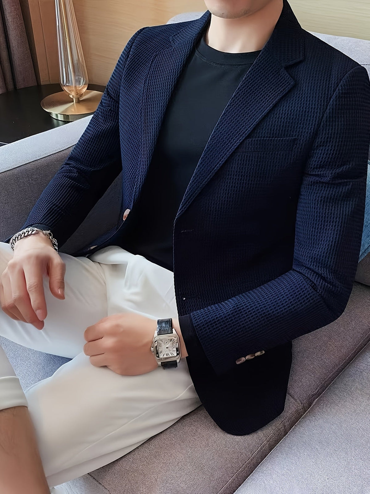Navy blue waffle knit blazer with a notch lapel, worn open over a casual outfit.