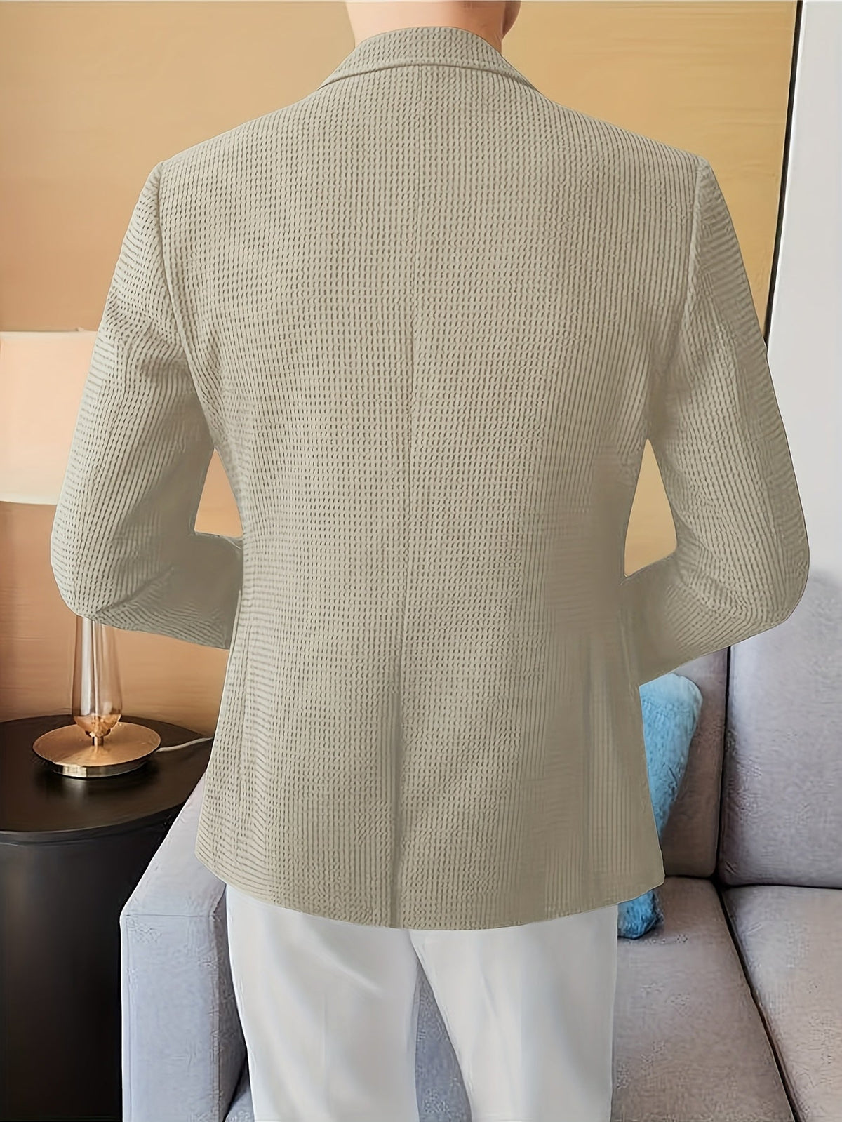 Black waffle knit blazer with a notch lapel, worn open over a casual outfit.
