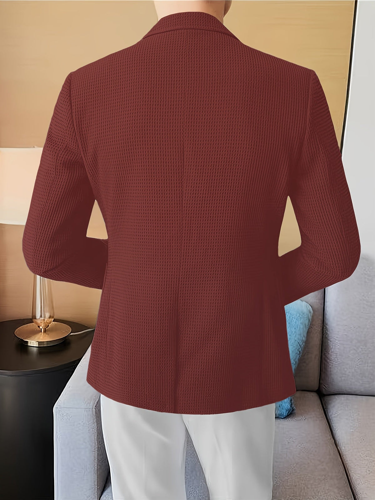 Black waffle knit blazer with a notch lapel, worn open over a casual outfit.