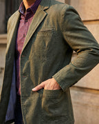 Men's tailored denim blazer in olive green, worn open over a check shirt