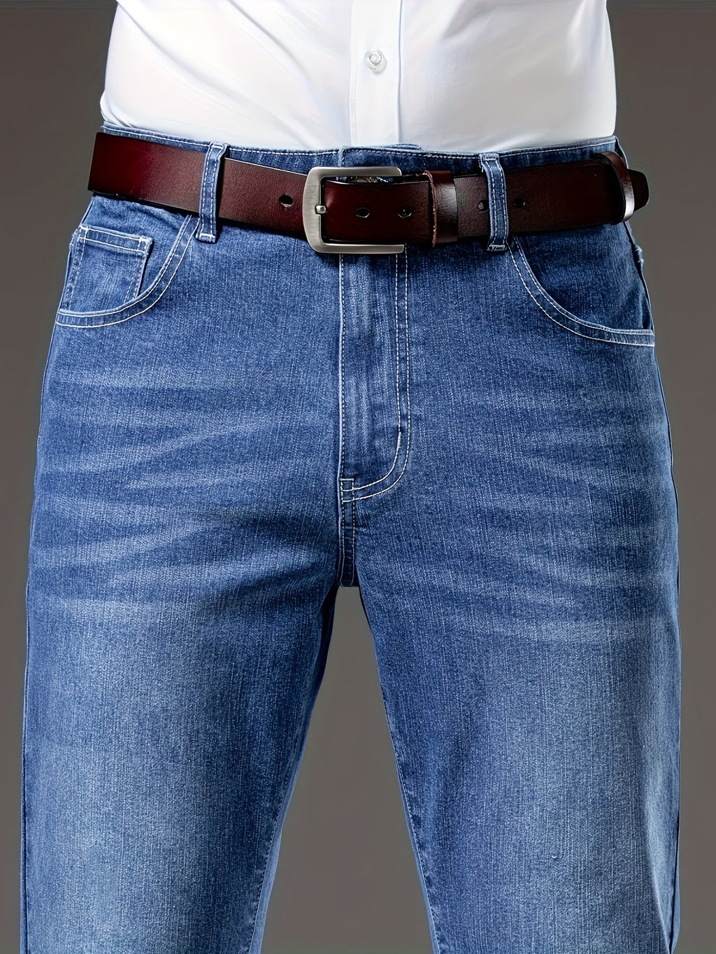 Blue regular-fit straight-leg jeans, close-up of the washed denim waist